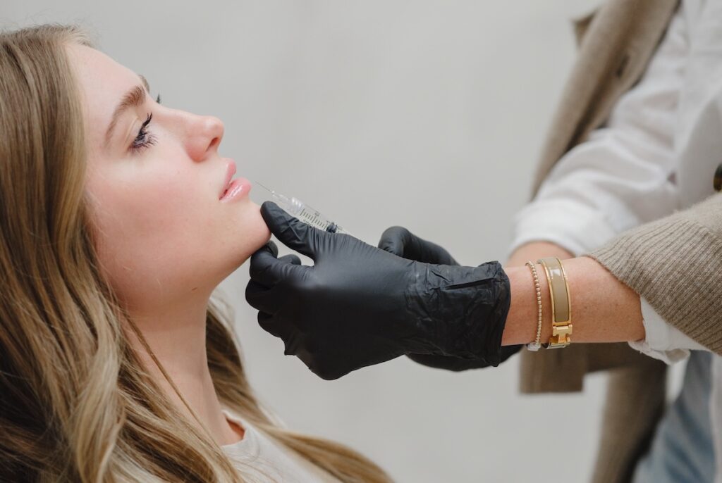 An injector at Honey Aesthetics carefully uses a small dose of Tox on a patient's lip to provide a lip flip near Minneapolis.