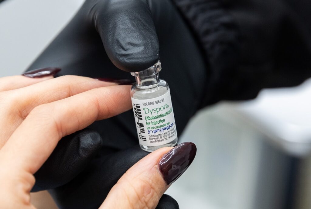 A close-up of a provider and patient holding a vial of Dysport near St. Paul.